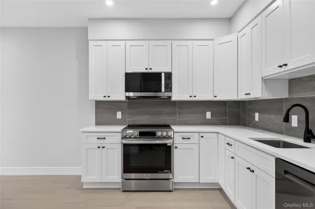 a kitchen with white cabinets and stainless steel appliances