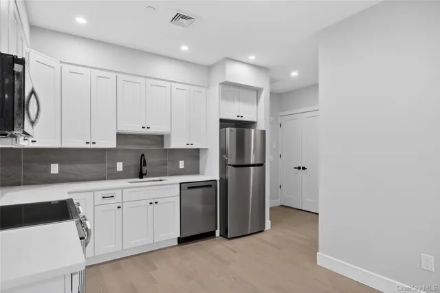 a kitchen with stainless steel appliances a refrigerator sink and cabinets