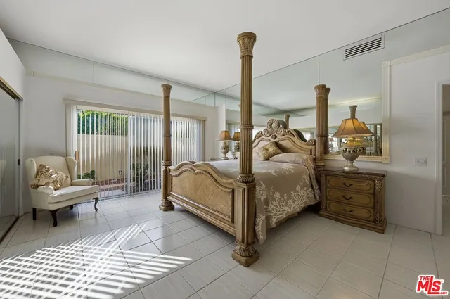 a spacious bedroom with a bed and glass door