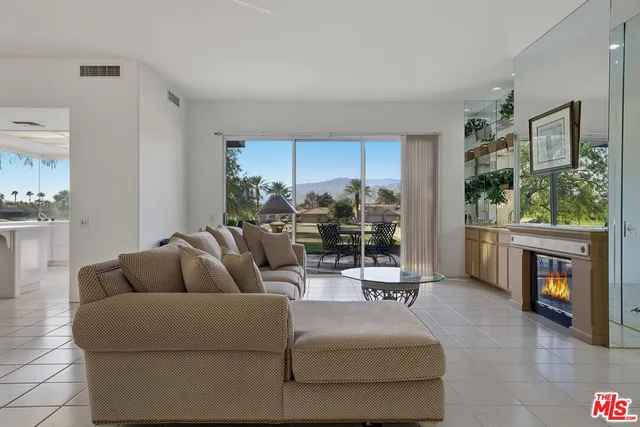 a living room with furniture and a floor to ceiling window