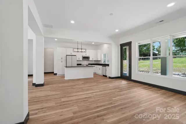 a view of a kitchen with refrigerator and wooden floor