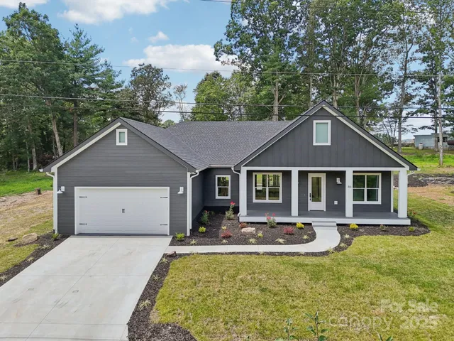 a front view of house with yard and trees in the background