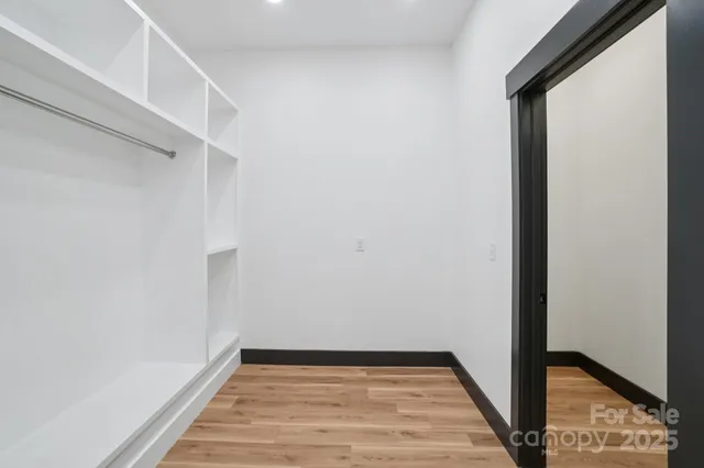 a view of a room with wooden floor and hallway