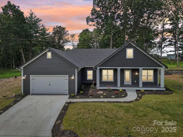 a front view of house with yard and trees in the background