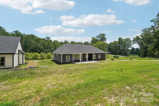 a view of a big house with a big yard and large trees