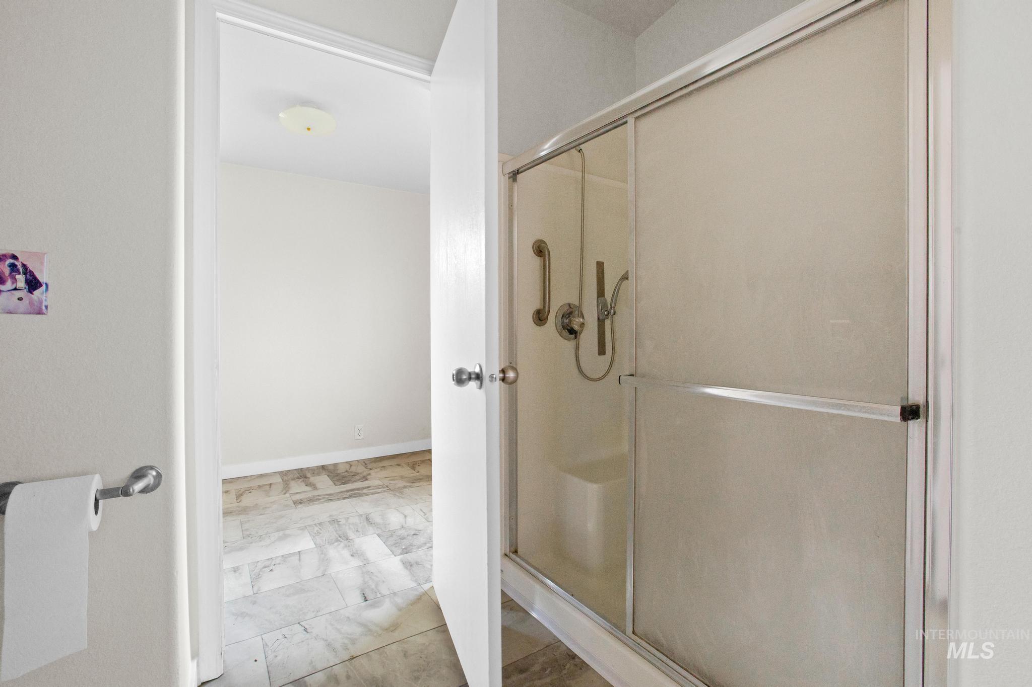 15190 Oasis Road Caldwell, ID 83607 - Photo 23 of 36 Shower enclosure with frosted glass panels, an integrated shower seat, and grab bars