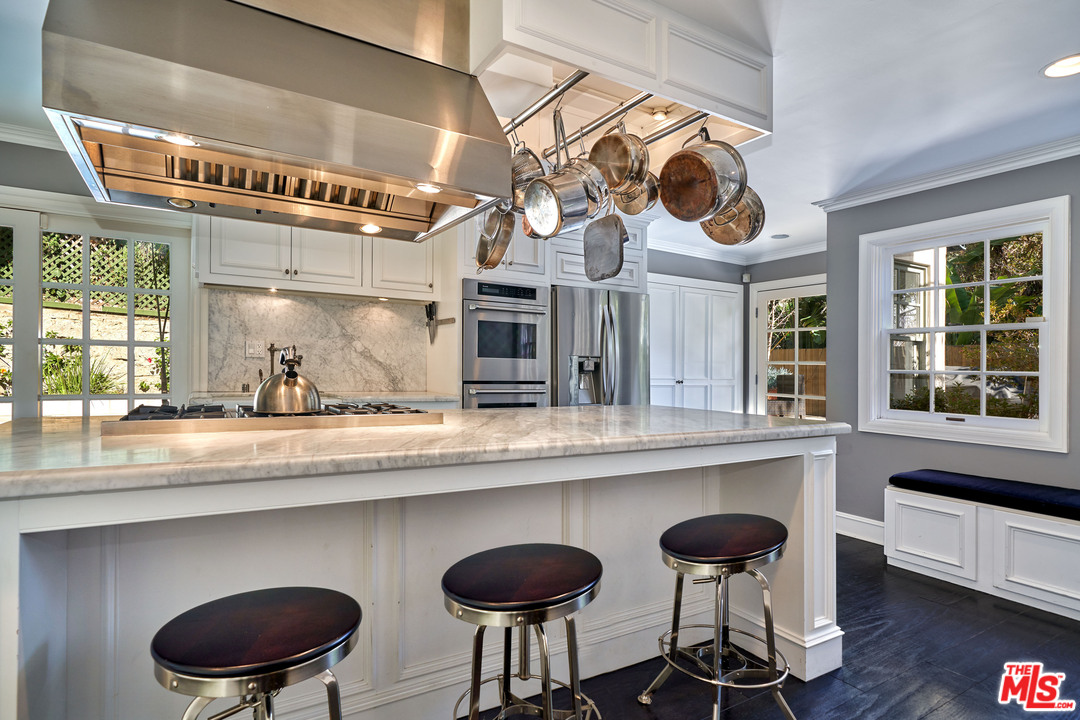 1488 North Kings Road Los Angeles, CA 90069 - Photo 13 of 53 a kitchen with a cabinets a sink and chairs in it