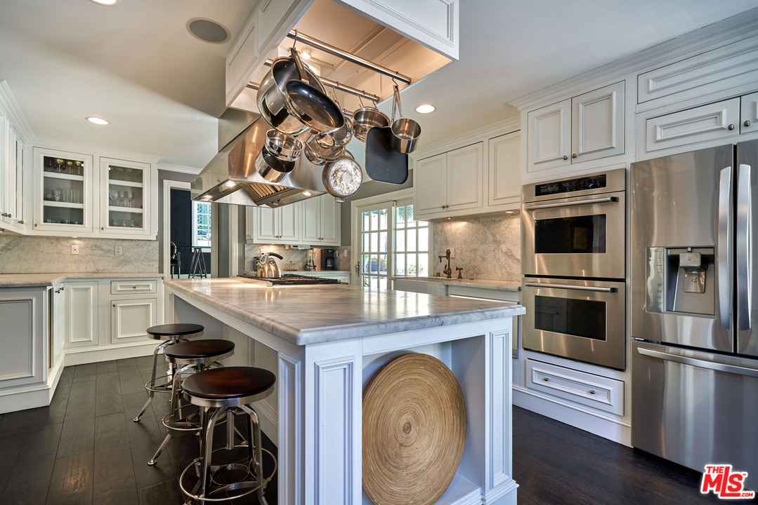 1488 North Kings Road Los Angeles, CA 90069 - Photo 15 of 53 a kitchen with stainless steel appliances granite countertop a stove and a refrigerator
