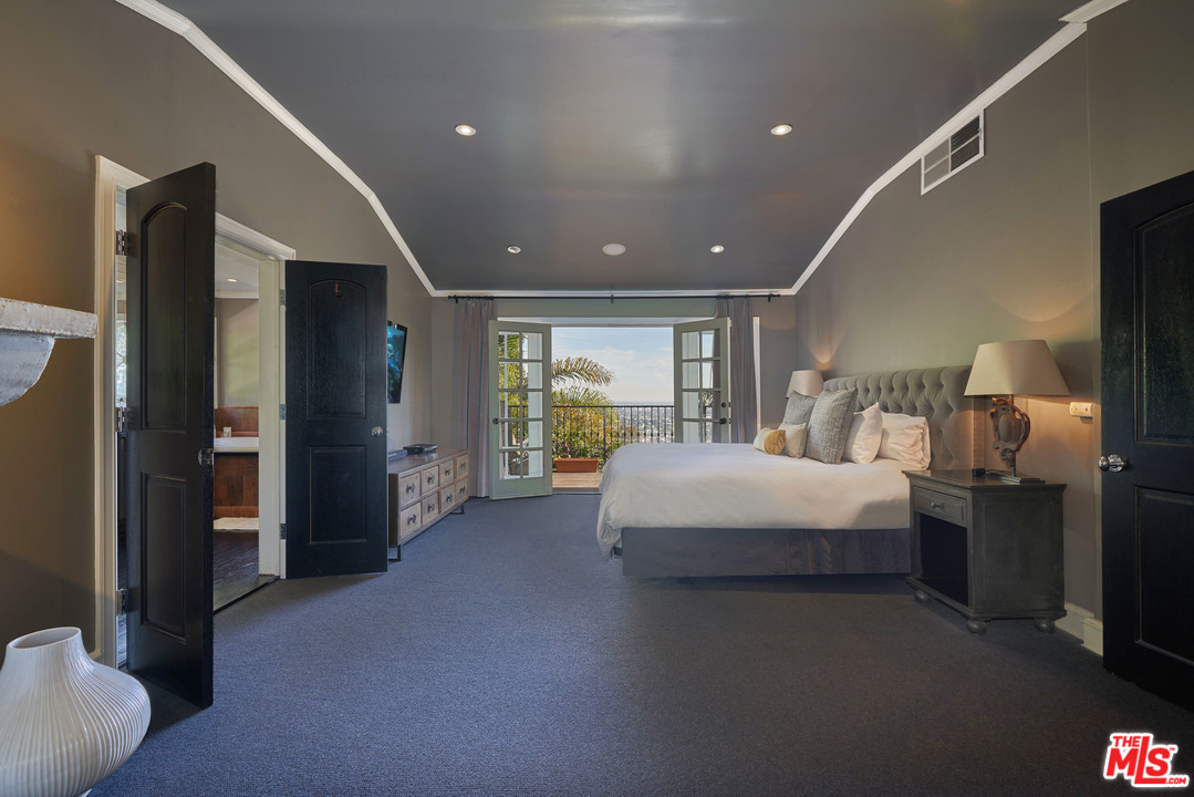 1488 North Kings Road Los Angeles, CA 90069 - Photo 27 of 53 a large bedroom with a bed and glass walk in closet