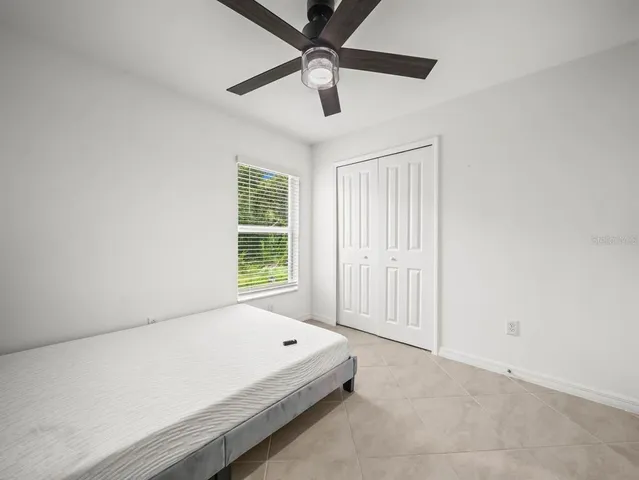 an empty room with fan and windows