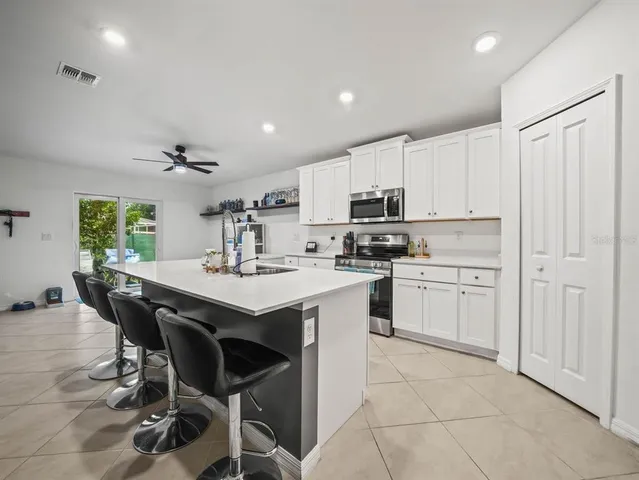 a kitchen with white cabinets stainless steel appliances and a center island