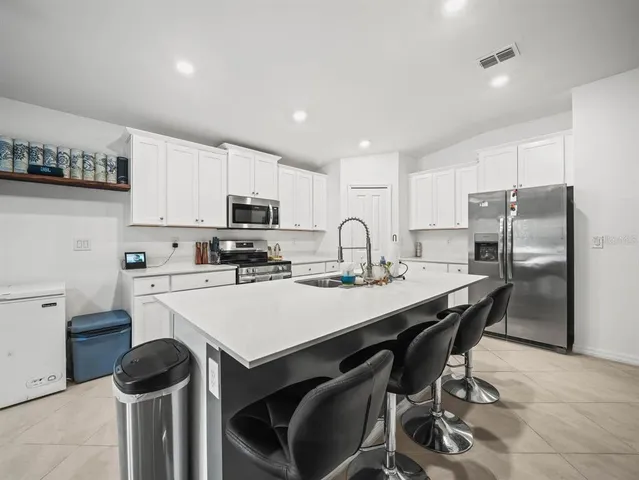 a kitchen with a sink a stove a refrigerator and cabinets
