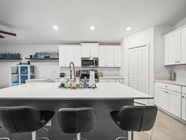a kitchen with granite countertop a sink counter top space cabinets and stainless steel appliances