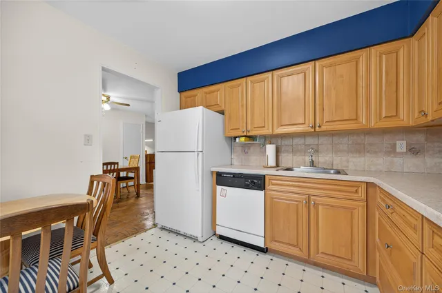 a kitchen with stainless steel appliances a refrigerator a sink a stove a table and chairs
