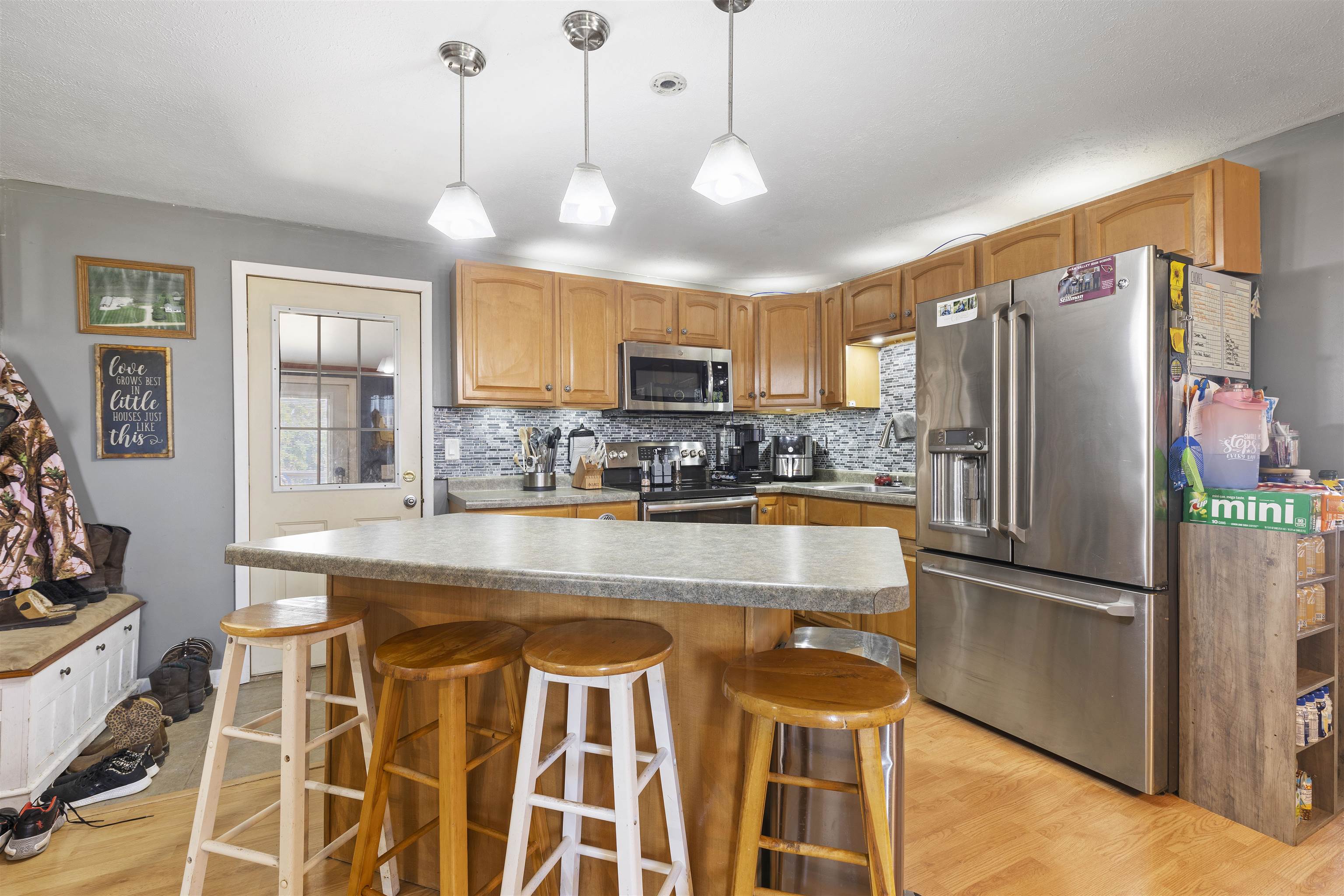 10784 East Utility Road Stillman Valley, IL 61084 - Photo 7 of 23 a kitchen with stainless steel appliances granite countertop a refrigerator a stove a sink dishwasher a dining table and chairs with wooden floor
