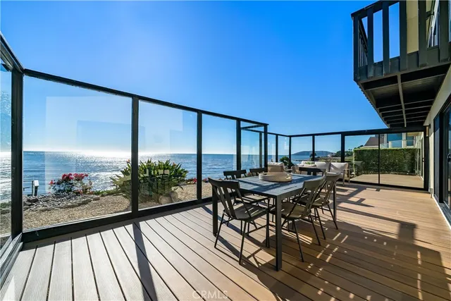 a view of a patio with table and chairs under an umbrella with wooden floor