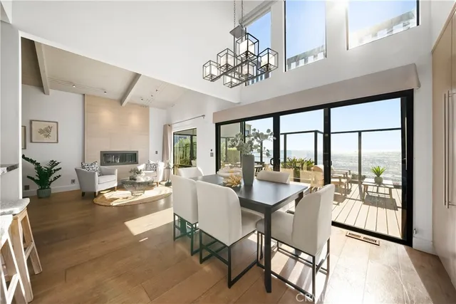 a view of a dining room with furniture a chandelier and wooden floor