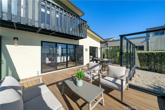 a view of a patio with couches table and chairs with wooden floor