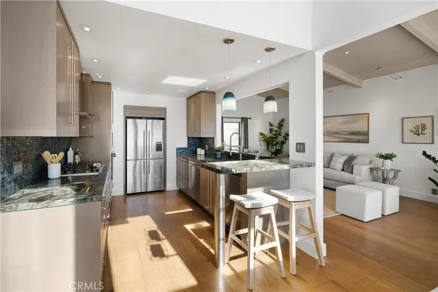 a kitchen with stainless steel appliances granite countertop a refrigerator and a stove