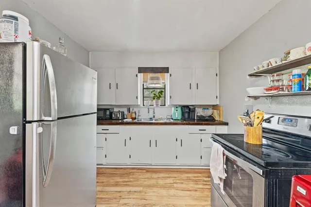a kitchen with a sink a refrigerator and cabinets