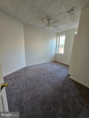 an empty room with a ceiling fan and a window