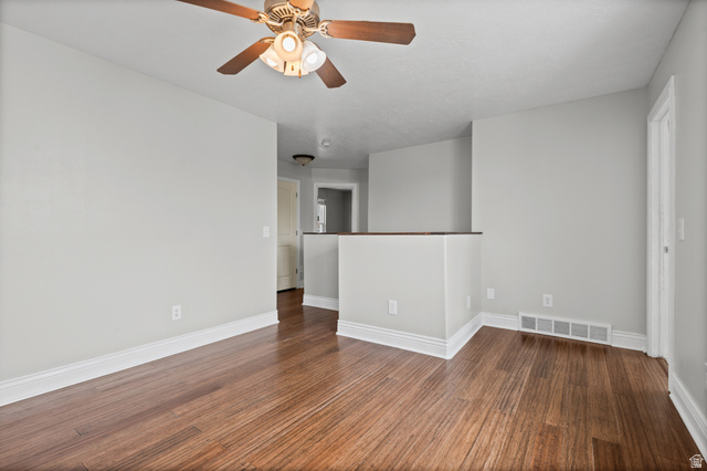 1346 Archmore Drive Springville, UT 84663 - Photo 12 of 32 Room featuring wood-finish flooring, a ceiling fan, light gray wall paint, white baseboards, and a half-wall partition