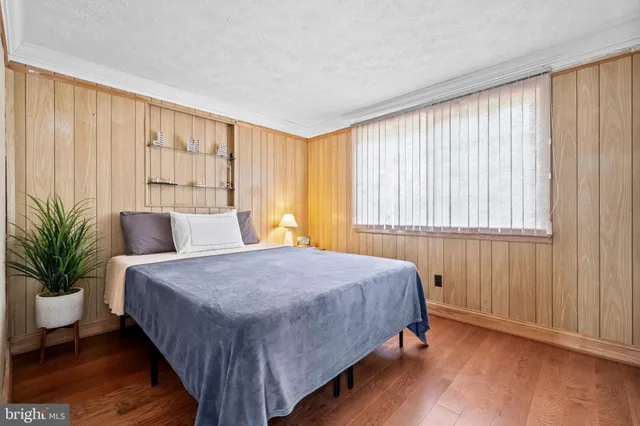 a bed sitting in a spacious bedroom next to a window