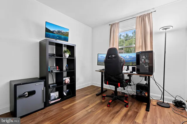 a view of a workspace with furniture and wooden floor