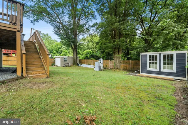 a view of a house with backyard and trees