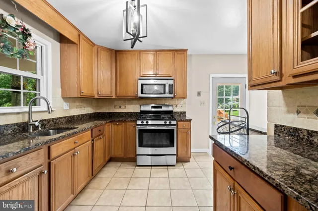 a kitchen with stainless steel appliances granite countertop a stove sink and cabinets