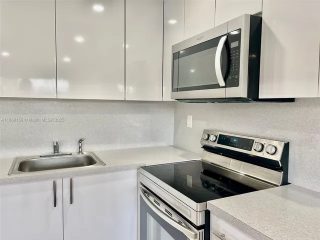 a kitchen with stainless steel appliances a sink a stove and cabinets