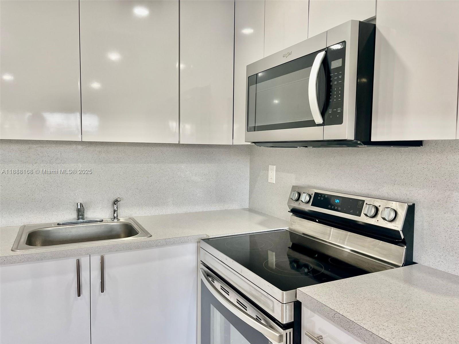 2255 Southeast 5th Street, Unit 10 Pompano Beach, FL 33062 - Photo 7 of 10 a kitchen with stainless steel appliances a sink a stove and cabinets