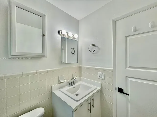 a bathroom with a sink a toilet and mirror
