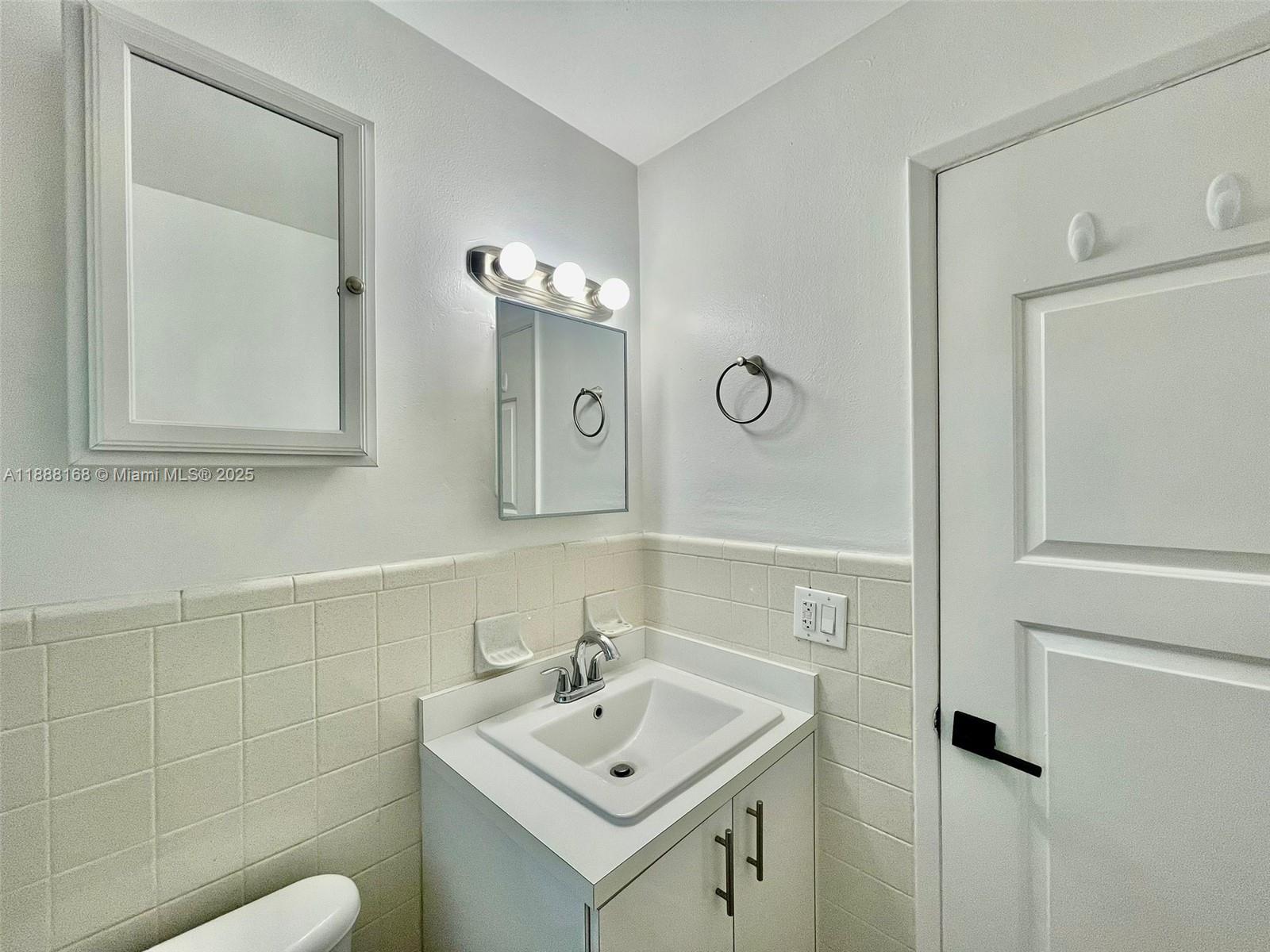 2255 Southeast 5th Street, Unit 10 Pompano Beach, FL 33062 - Photo 9 of 10 a bathroom with a sink a toilet and mirror