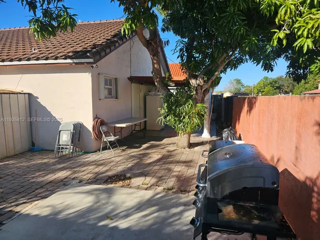 a view of a house with backyard and a tree