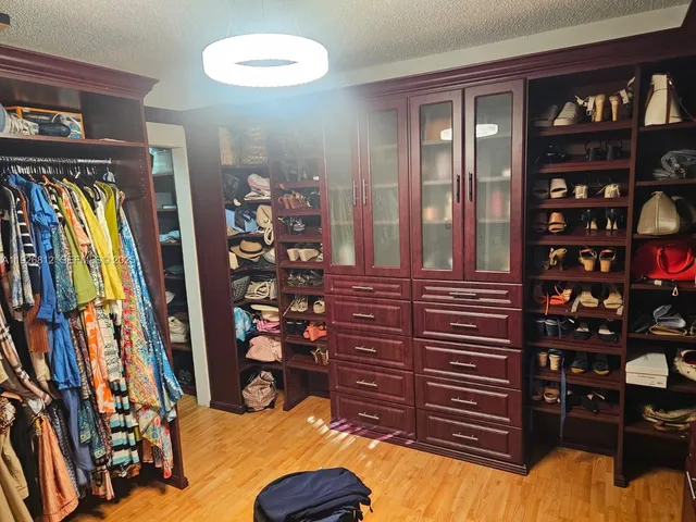 a view of walk in closet with clothes
