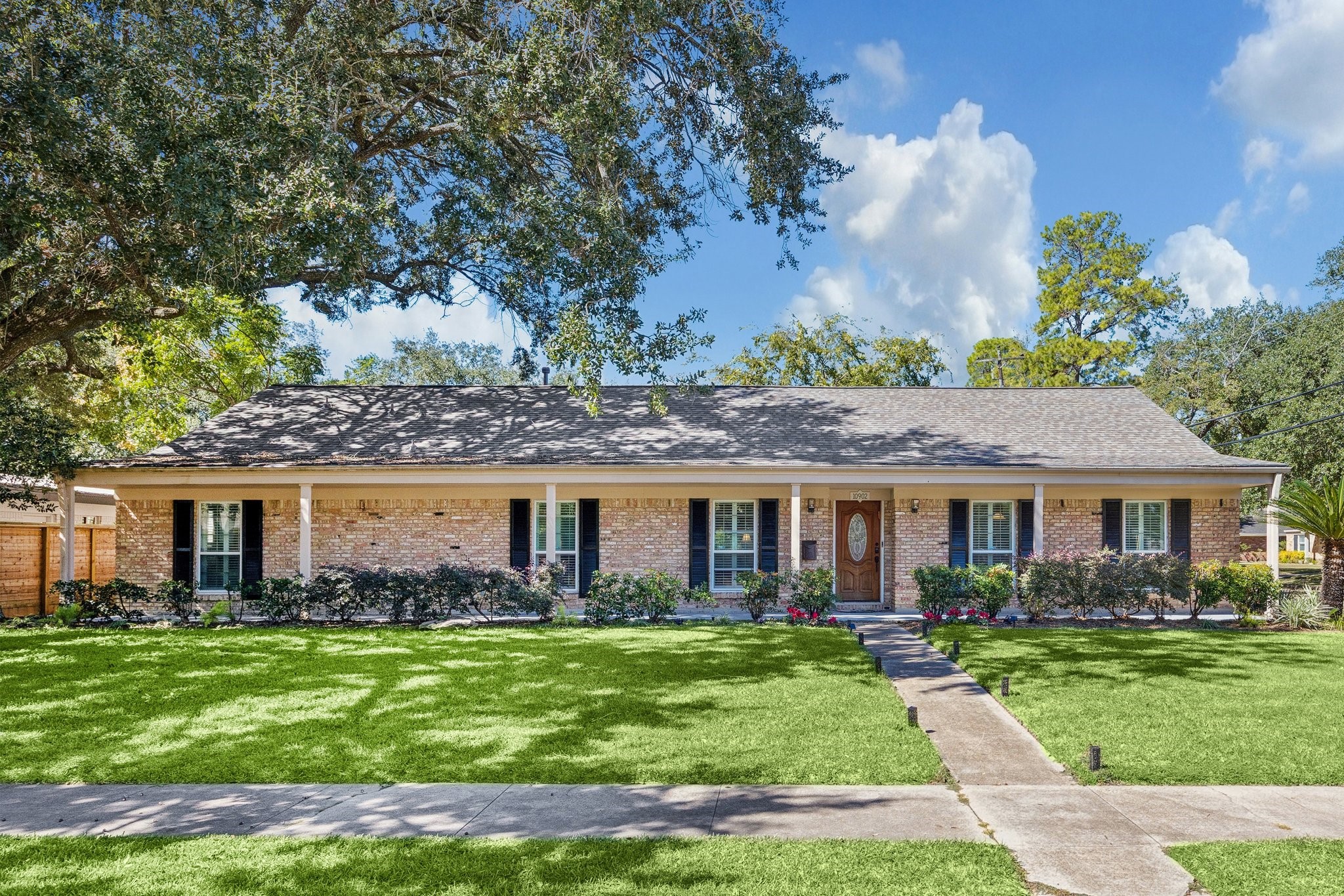 10902 Mullins Drive Houston, TX 77096 - Photo 1 of 20 a front view of a house with a garden
