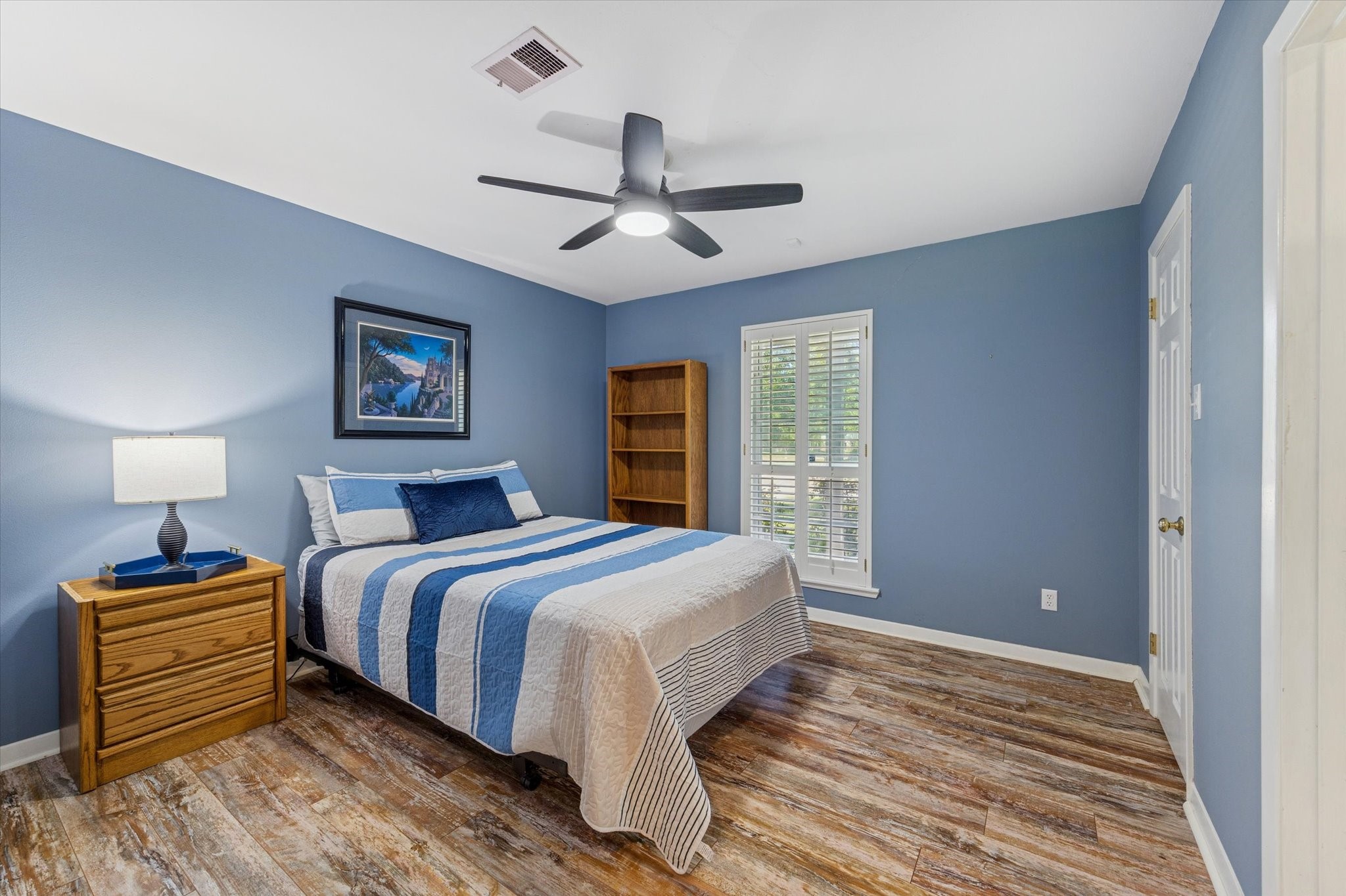 10902 Mullins Drive Houston, TX 77096 - Photo 12 of 20 a bedroom with a bed and wooden floor
