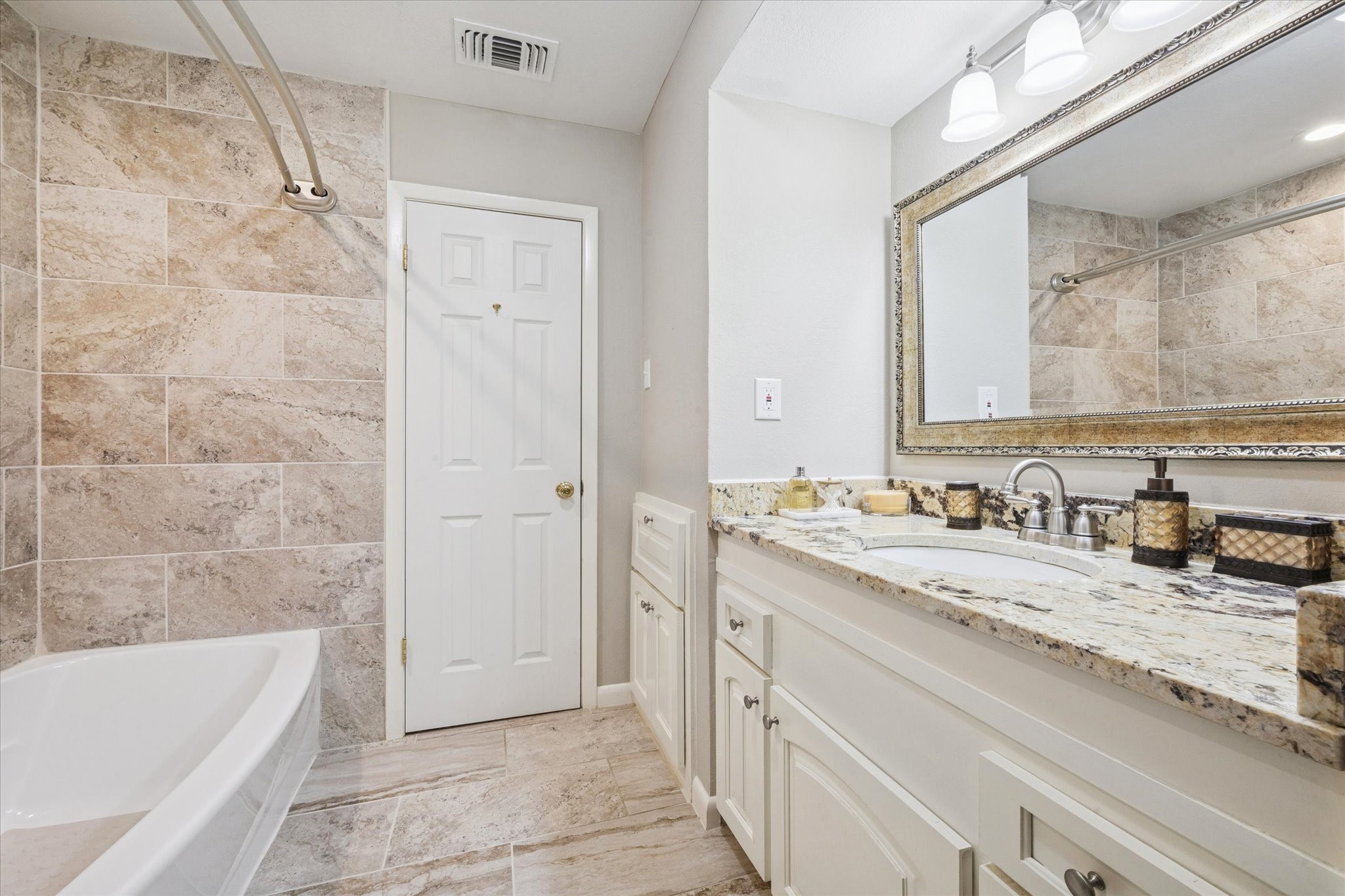 10902 Mullins Drive Houston, TX 77096 - Photo 14 of 20 a bathroom with a granite countertop bathtub sink vanity and mirror