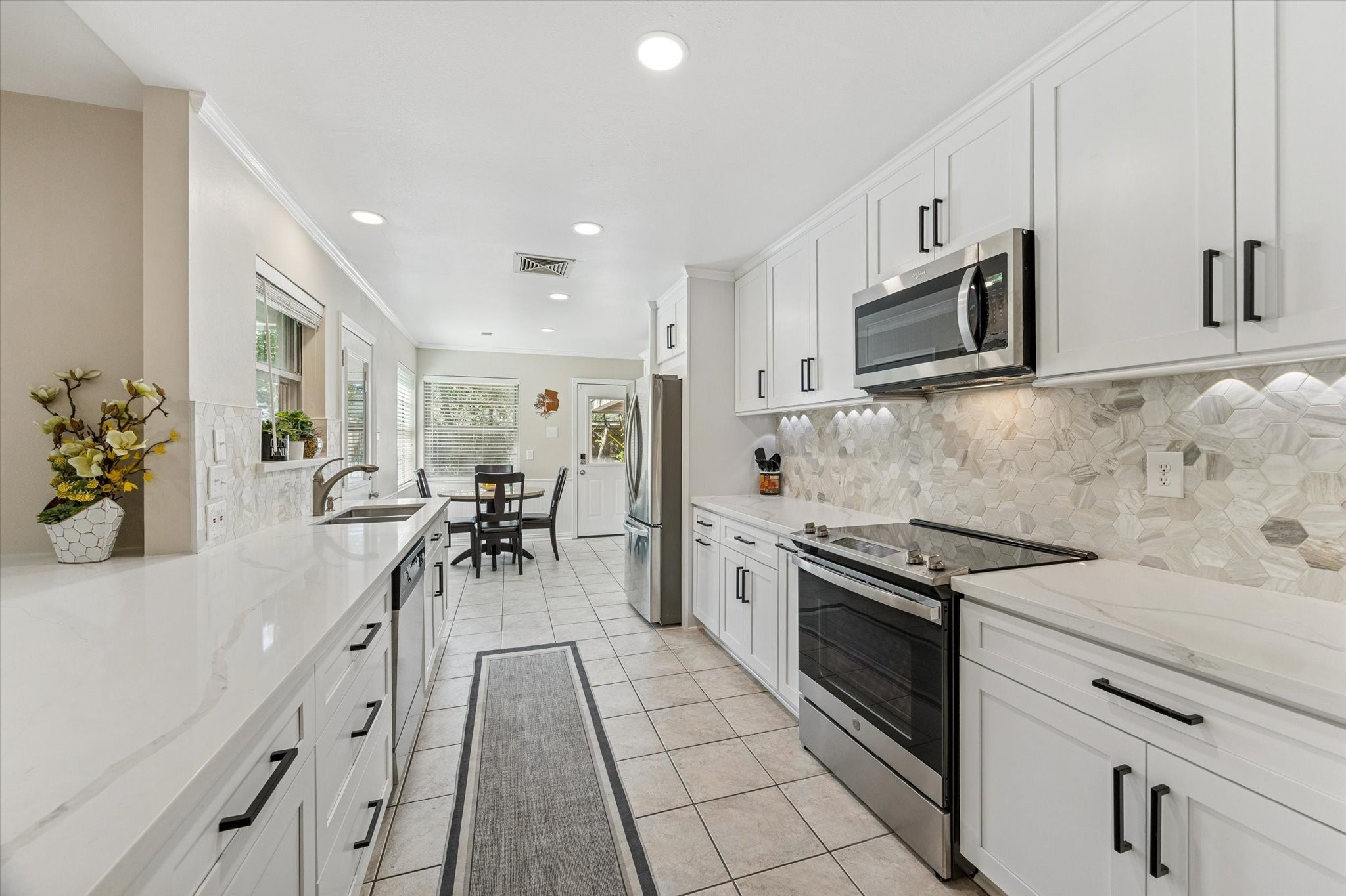 10902 Mullins Drive Houston, TX 77096 - Photo 3 of 20 a kitchen with stainless steel appliances granite countertop a stove a sink and a microwave