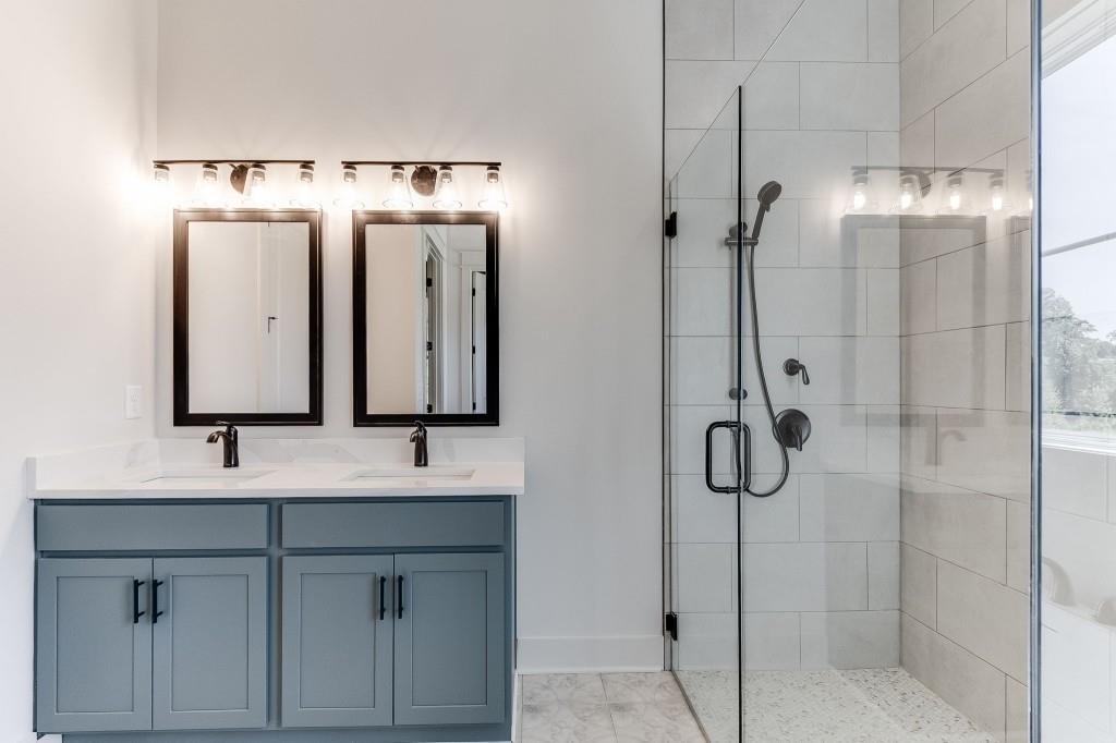62 Ridgewood Creek Path Dallas, GA 30157 - Photo 10 of 31 a bathroom with a double vanity sink a mirror and shower
