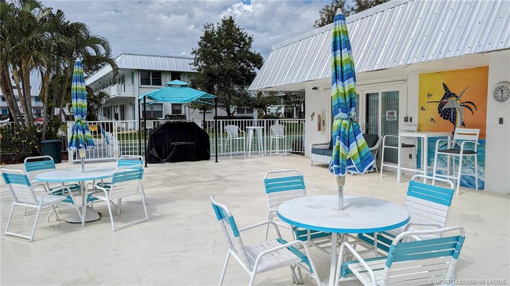 Undisclosed Address Stuart, FL 34996 - Photo 23 of 28 a view of a patio with table and chairs potted plants and palm tree