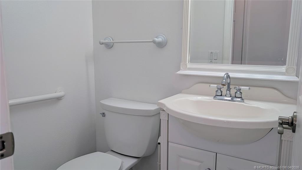 Undisclosed Address Stuart, FL 34996 - Photo 27 of 28 a bathroom with a sink a toilet and a mirror