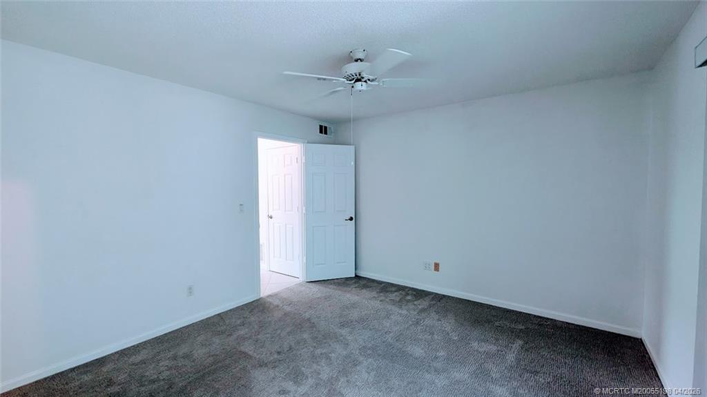 Undisclosed Address Stuart, FL 34996 - Photo 9 of 28 a view of a room with a ceiling fan and carpet
