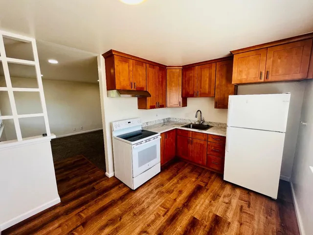 a kitchen with wooden cabinets and white appliances