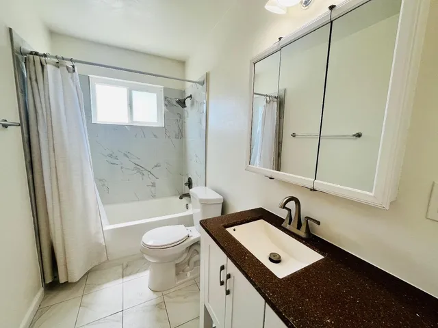 a bathroom with a sink a toilet and a mirror