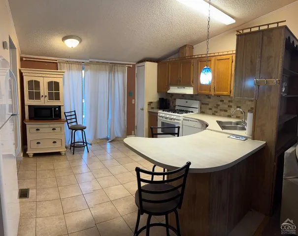 a kitchen with stainless steel appliances a stove a refrigerator and a refrigerator with wooden floor