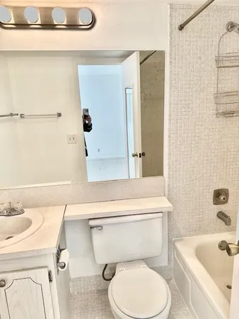 a white toilet sitting next to a bathroom sink and tub