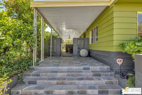 a view of a pathway of a house with potted plants