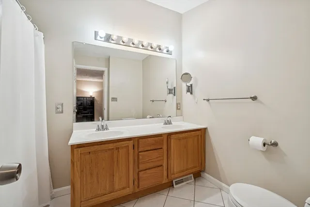 a bathroom with a granite countertop sink mirror and toilet